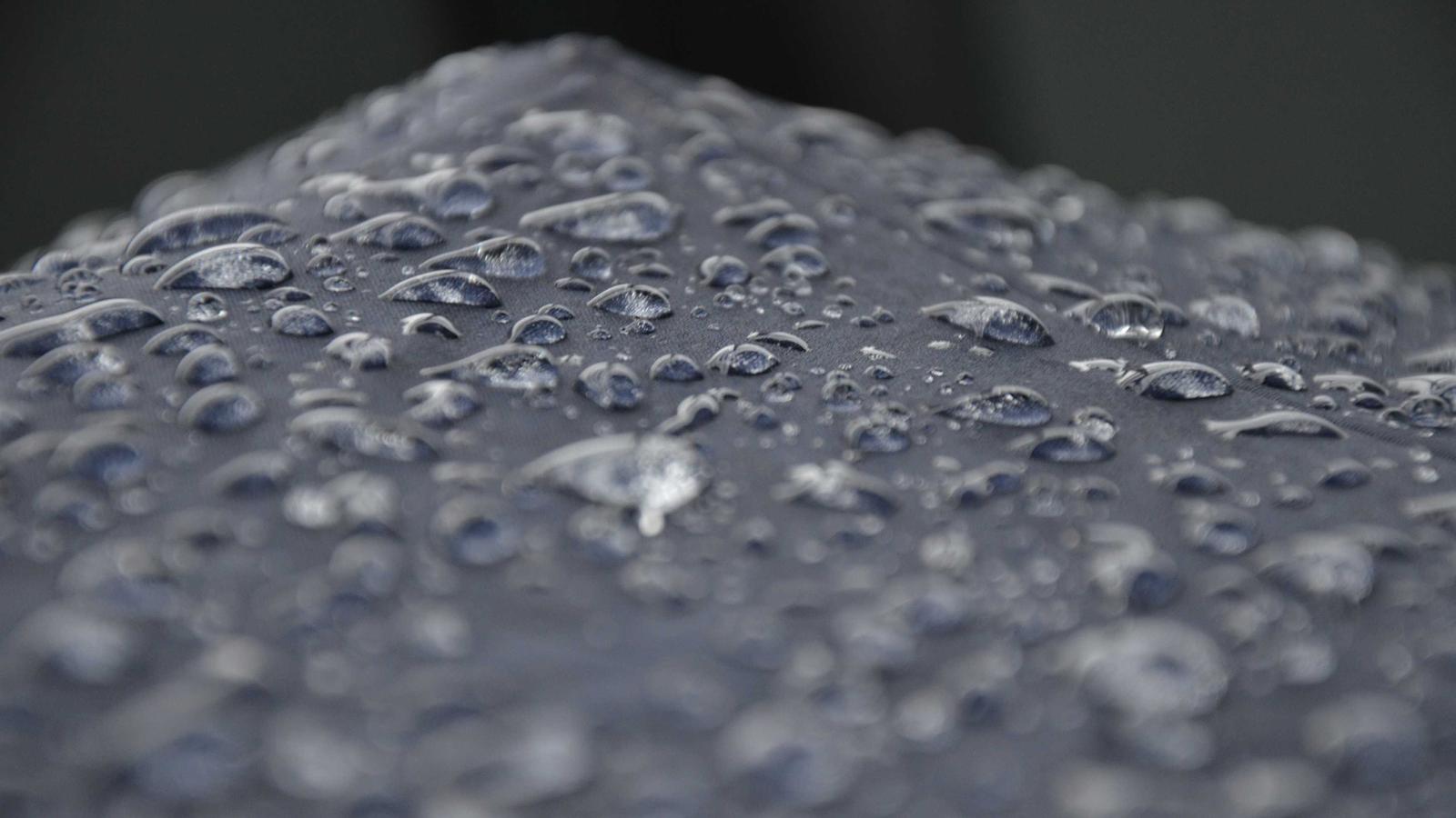Rain beaded across taut grey fabric, close up